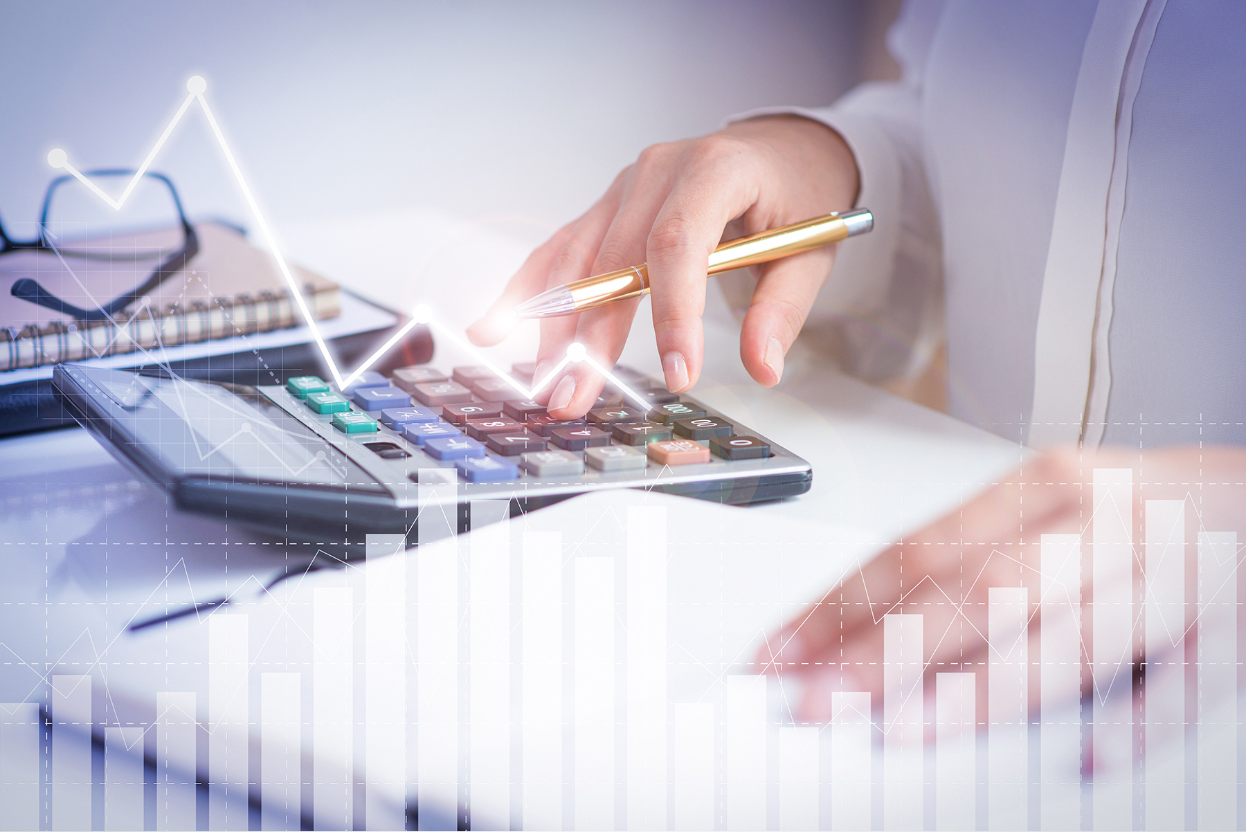 Accountant calculating profit with financial analysis graphs. Notebook, glasses and calculator lying on desk. Accountancy concept. Cropped view.